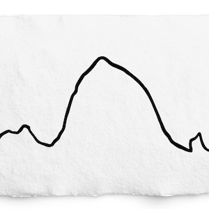 May include: A black line drawing of a mountain range on a textured white paper. The artwork features a central peak with smaller hills on either side, all rendered in a simple, minimalist style. The paper has a rough, uneven edge.