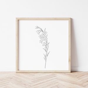 Op de afbeelding: Een zwart-witte lijntekening van een bloem met delicate bloemblaadjes en bladeren, ingelijst in een licht houten frame.