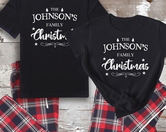 Könnte beinhalten: Passender schwarzer Schlafanzug mit rot-schwarzen karierten Hosen. Die Shirts haben einen weißen Text, der "The Johnson's Family Christmas" mit einer kleinen Weihnachtsbaumgrafik sagt.
