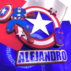 Puede incluir: Adorno para tarta de varias capas con el Capit&aacute;n Am&eacute;rica con su escudo, una gran estrella y el n&uacute;mero 6. El nombre "ALEJANDRO" se muestra debajo. El dise&ntilde;o incorpora los colores rojo, blanco, azul y plateado, ideal para una fiesta de cumplea&ntilde;os.