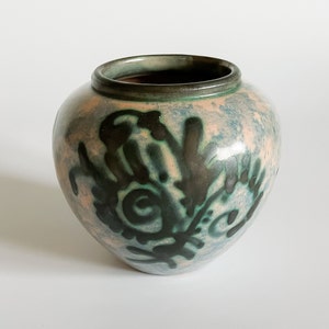 Könnte beinhalten: Eine kleine, runde Keramikvase mit hellblauer und rosafarbener Glasur. Die Vase hat ein dunkelgrünes und schwarzes abstraktes Design.