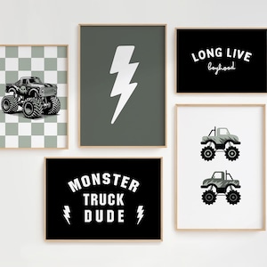 May include: Five framed wall art prints. One features a monster truck on a checkered background. Another has a white lightning bolt on a green background. A third print says "LONG LIVE boyhood". The fourth print says "MONSTER TRUCK DUDE". The last print has two monster truck illustrations.