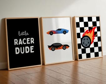 May include: Three framed wall art prints in light wood frames. The first is black with the white text "little RACER DUDE". The second is white with two sports cars featuring orange and yellow flame decals. The third has a black and white checkered pattern with a single tire graphic surrounded by orange and yellow flames.