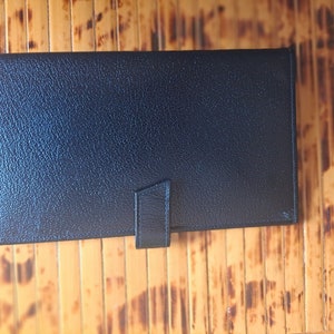 May include: A black leather passport holder with a flap closure.