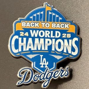 以下が含まれることがあります： 青と白の金属製エナメルピンで、BACK TO BACK 24 WORLD 25 CHAMPIONSの文字とLAドジャースのロゴがデザインされています。上部には旗が掲げられたスタジアムのシルエットがあり、下部には筆記体でDodgersと記されています。