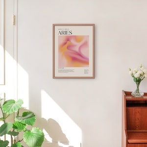 May include: A framed poster featuring an abstract design in shades of pink and yellow. The poster includes the text "ARIES" and "March 21 - April 19".