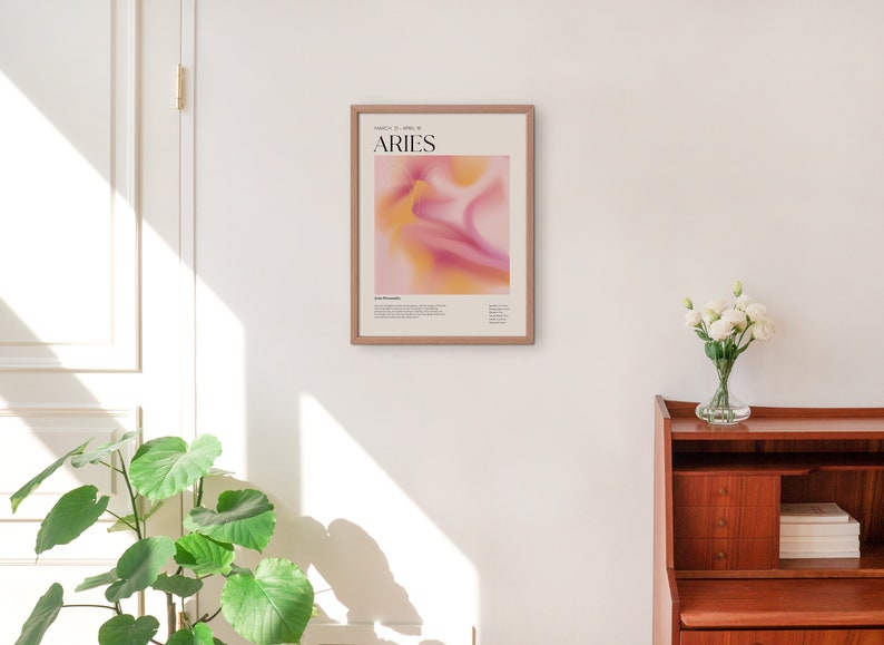 May include: A framed poster featuring an abstract design in shades of pink and yellow. The poster includes the text "ARIES" and "March 21 - April 19".