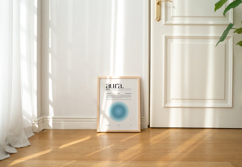 May include: A framed print with the word "aura." in black text on a white background. The print features a blue and white gradient circle in the center.