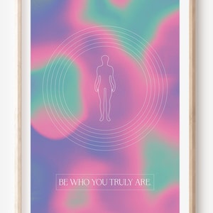 May include: A framed print with a pink, purple, and green gradient background. A white outline of a person is in the center of the print, surrounded by concentric circles. The text "BE WHO YOU TRULY ARE." is at the bottom of the print.