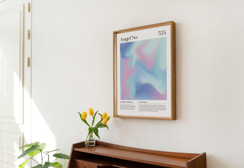 May include: A framed print with a light blue, pink, and purple gradient background. The print has the text "Angel No. 555" at the top. The print is in a wooden frame.