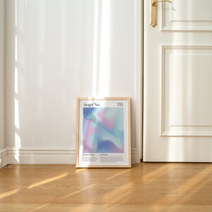 May include: A framed print with a light blue, pink, and purple abstract design. The print has the text "Angel No. 533" at the top.