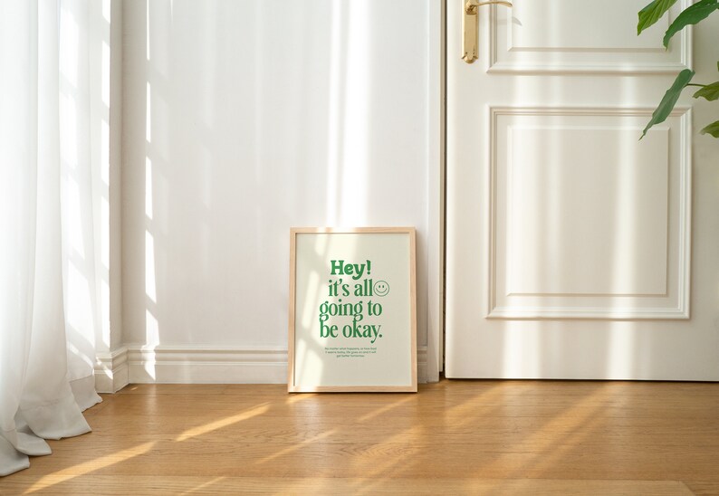 May include: A framed print with a white background and green text that reads "Hey! It's all going to be okay."  A green smiley face is next to the text.