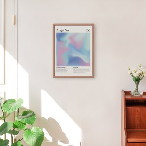 May include: A framed print with a light blue, pink, and purple abstract design. The print has the text "Angel No. 333" at the top. The text below the design reads "The number 3 is symbolic of expansion, growth, and abundance. It is a reminder that you are supported and guided by the divine.  Angel Message: Trust your intuition and follow your heart. You are on the right path."