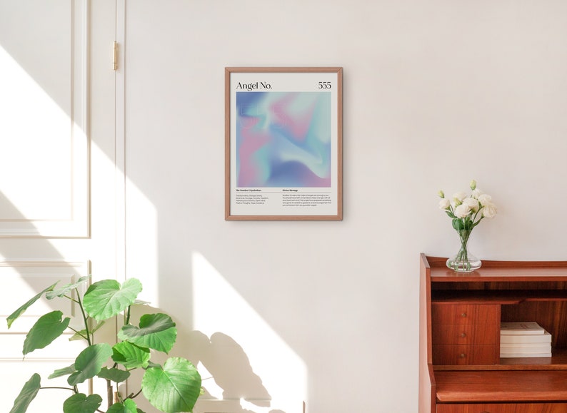 May include: A framed print with a light blue, pink, and purple abstract design. The print has the text "Angel No. 333" at the top. The text below the design reads "The number 3 is symbolic of expansion, growth, and abundance. It is a reminder that you are supported and guided by the divine.  Angel Message: Trust your intuition and follow your heart. You are on the right path."