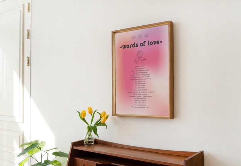 Pode incluir: Uma impress&atilde;o emoldurada com um fundo degrad&ecirc; rosa e roxo. A impress&atilde;o apresenta uma ilustra&ccedil;&atilde;o em preto e branco de uma rosa e o texto "words of love" em preto. A impress&atilde;o est&aacute; pendurada em uma parede branca.