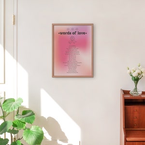 Pode incluir: Uma impress&atilde;o emoldurada com um fundo degrad&ecirc; rosa e roxo. A impress&atilde;o apresenta o texto "words of love" em preto e uma lista de palavras em um tipo de letra menor. A impress&atilde;o est&aacute; pendurada em uma parede branca.