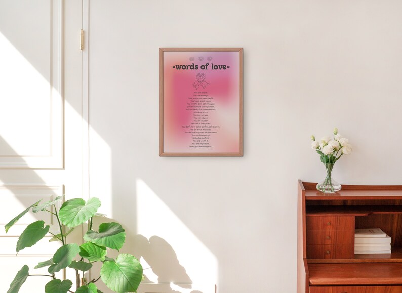 Pode incluir: Uma impress&atilde;o emoldurada com um fundo degrad&ecirc; rosa e roxo. A impress&atilde;o apresenta o texto "words of love" em preto e uma lista de palavras em um tipo de letra menor. A impress&atilde;o est&aacute; pendurada em uma parede branca.