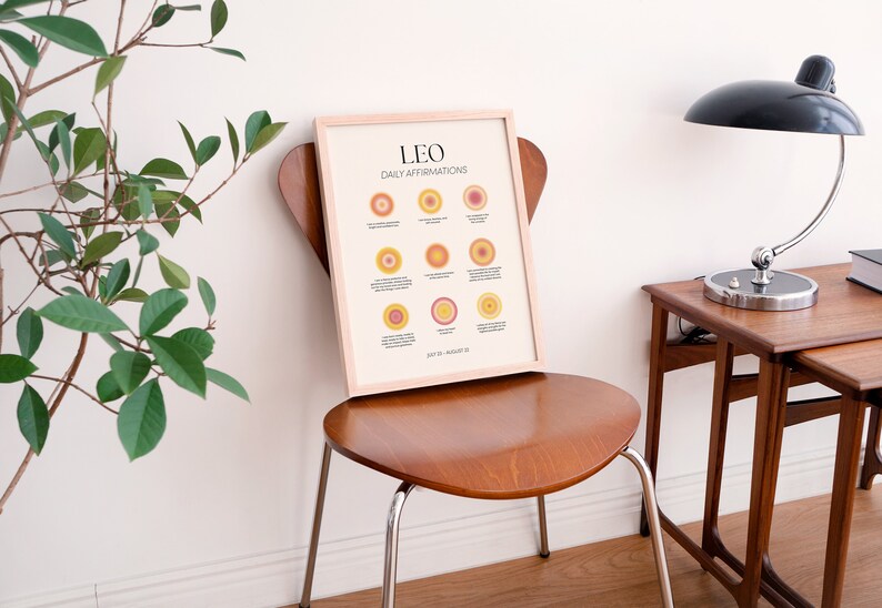 May include: A framed print with the text "LEO DAILY AFFIRMATIONS" and a graphic of 12 orange and yellow circles with text inside each circle. The text at the bottom of the print reads "July 23 - August 22".