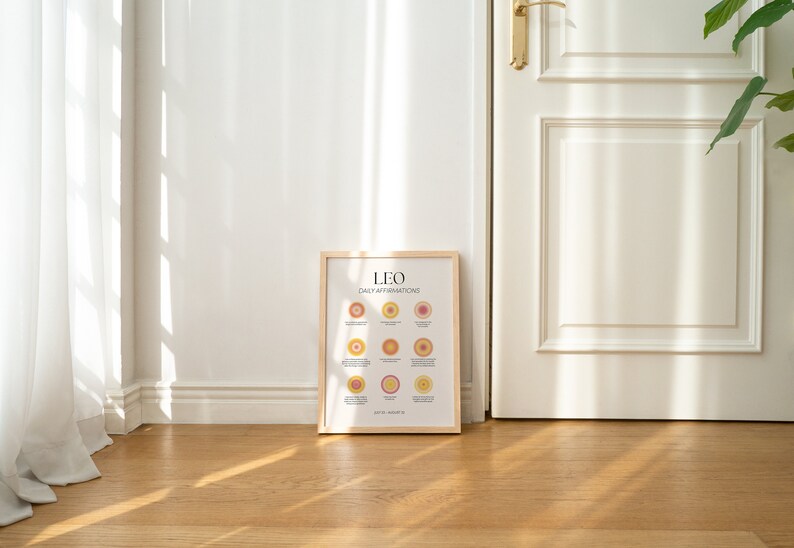May include: A framed print with a light wood frame. The print is white with black text that reads "LEO DAILY AFFIRMATIONS". The print features a series of colorful circles with text inside each circle.