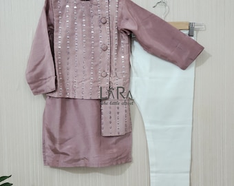 Puede incluir: Conjunto infantil de túnica color malva con chaleco de lentejuelas y cuello mandarín, y pantalón blanco. La túnica tiene mangas largas. El conjunto se muestra en una percha. Es de estilo formal.
