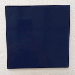 May include: A solid dark blue square tile.