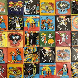 May include: A collection of colorful square tiles featuring Day of the Dead themed illustrations. Each tile depicts skeletons in various scenes, including dancing, playing instruments, and wearing festive hats. The tiles are in a variety of colors, including orange, blue, green, and red.