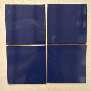 May include: Four square blue ceramic tiles arranged in a grid pattern.