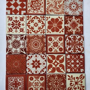 May include: A collection of twenty square ceramic tiles arranged in a grid, each featuring a unique terracotta-colored pattern on a cream-colored background. The designs include various floral, geometric, and symmetrical motifs across all tiles.