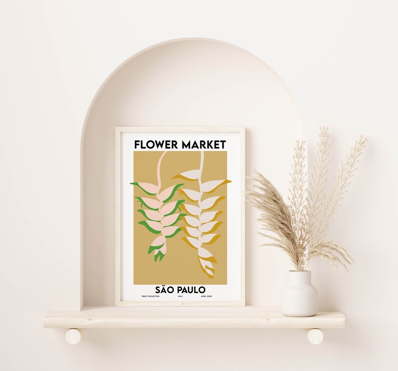 K&ouml;nnte beinhalten: Ein gerahmter Druck mit einem minimalistischen Design, das eine stilisierte Illustration einer rosa und gr&uuml;nen Blume auf gelbem Hintergrund zeigt. Der Text "FLOWER MARKET" und "S&Atilde;O PAULO" ist in Schwarz gedruckt.