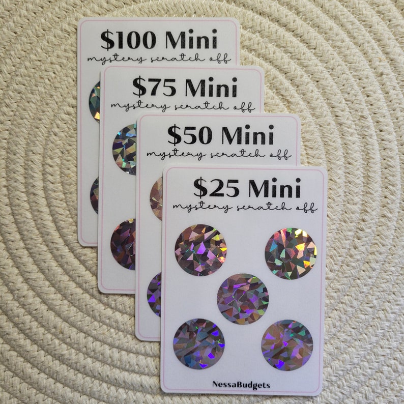 May include: Four white cards with holographic scratch-off circles. The cards are stacked on top of each other. The top card has the text "$100 Mini mystery scratch off". The second card has the text "$75 Mini mystery scratch off". The third card has the text "$50 Mini mystery scratch off". The bottom card has the text "$25 Mini mystery scratch off" and the text "NessaBudgets".