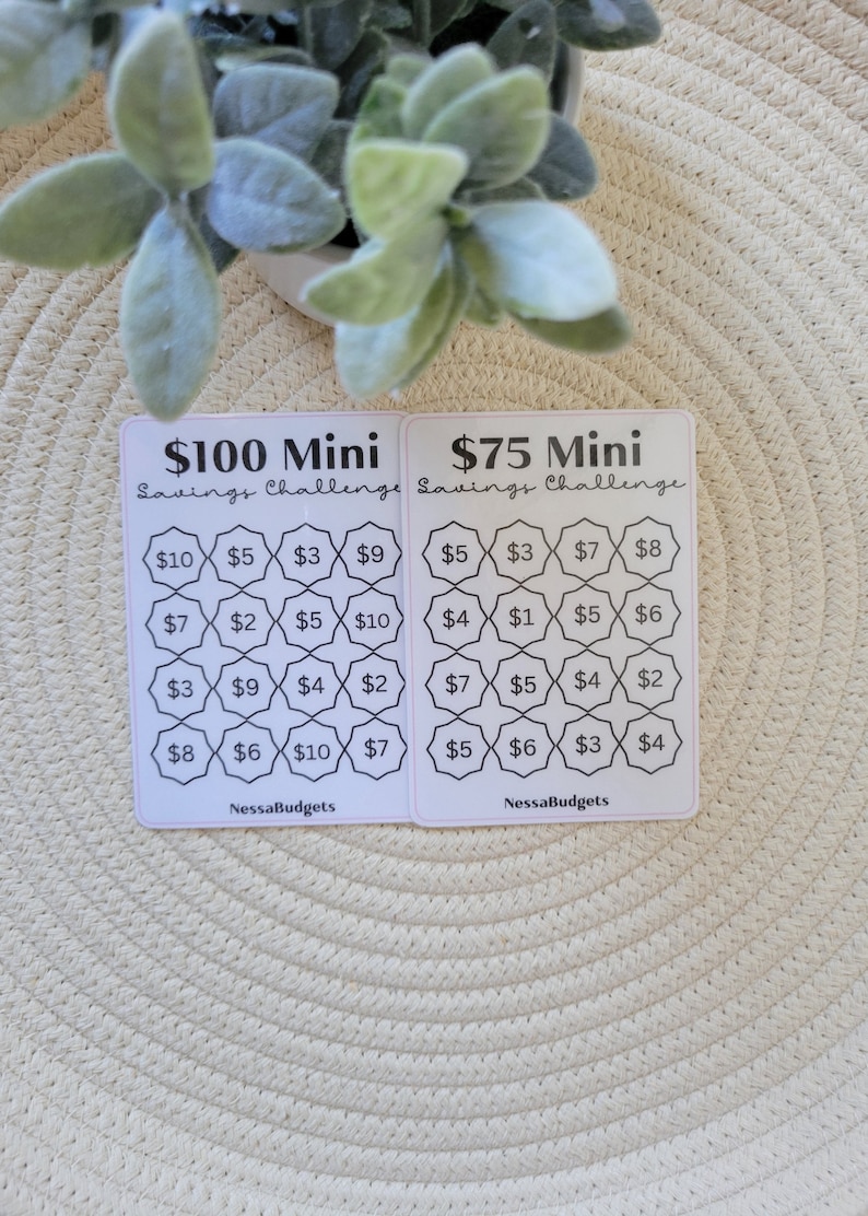May include: Two printable cards for a savings challenge. The cards are white with black text and lines. The left card is for a $100 mini savings challenge and the right card is for a $75 mini savings challenge. Each card has a grid of 16 squares with dollar amounts in each square.