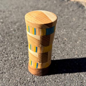May include: A set of three ceramic mugs with a speckled, matte finish. The mugs are in shades of cream, light gray, and dark gray. Each mug has a simple, minimalist design and a rounded handle.