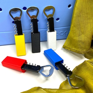 May include: Five different bottle openers with a corkscrew feature. The openers are in various colours, including yellow, black, white, blue, and red. The openers are made of metal and have a silver finish.