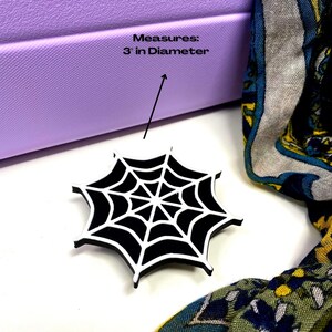 May include: Black and white spiderweb design with a 3 inch diameter. The spiderweb is made of a thick, durable material and is perfect for adding a spooky touch to your home decor.