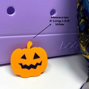 May include: Orange pumpkin-shaped Halloween charm with a black jack-o'-lantern face. The charm measures 3 inches long by 2.9 inches wide.