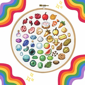 Puede incluir: Un aro de bordado redondo con fondo blanco e imágenes pixeladas de colores de varios objetos, incluyendo frutas, verduras, gemas y otros objetos. El aro está rodeado por un borde de arcoíris.