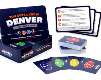 Può includere: Una scatola di latta blu con il testo "You Gotta Know Denver Sports Trivia Game" sul davanti. La scatola contiene 125 carte e 600 domande. La scatola è aperta e ci sono delle carte all'interno. Le carte sono blu con testo bianco e una stella rossa. Le carte hanno dei numeri su di esse. Le carte sono per un gioco di quiz sui giochi sportivi di Denver.