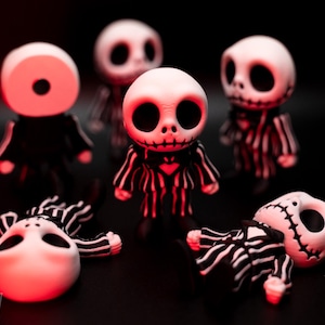 May include: A collection of Jack Skellington figurines. The figures are white with black eyes and mouths, and wear black and white striped suits. Some figures are standing, while others are lying down. The background is black.