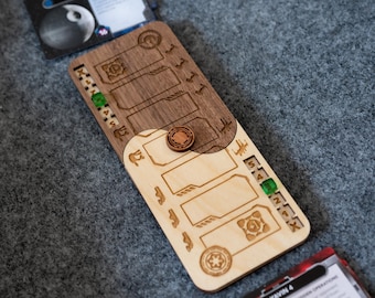May include: A wooden game board with two sides, one brown and one natural wood. The board has slots for cards and a token in the center. The board is marked with numbers and symbols.