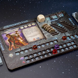 May include: A detailed board game setup featuring a wooden game board with slots for cards, dice, and tokens. The board has etched designs and numbers. A card with a character illustration is visible, along with a stack of cards and a die.