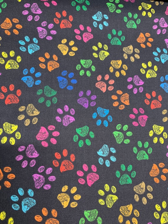 Novelty Fabric by the Yard. Rainbow Paw Prints- Black background. 100% cotton by the yard