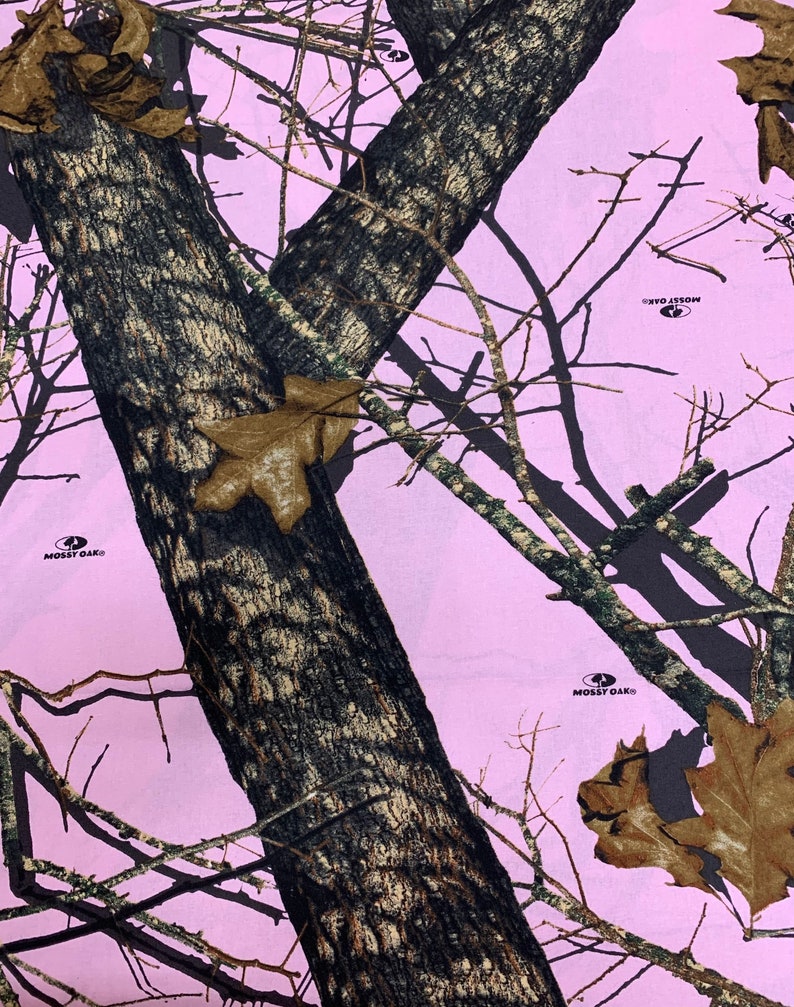 May include: Pink camouflage fabric with a tree trunk pattern and the Mossy Oak logo repeated throughout.