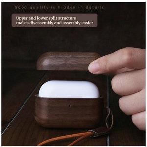 May include: A wooden case for wireless earbuds, with a dark brown wood finish and a light brown leather strap. The case is open, revealing a white inner compartment. The text "Good quality is hidden in details" and "Upper and lower split structure makes disassembly and assembly easier" is visible on the image.
