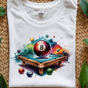 Peut inclure: Un t-shirt blanc avec un motif aquarelle d'un billard et de boules de billard. La boule 8 est au centre du motif et est entourée d'autres boules et d'un billard.