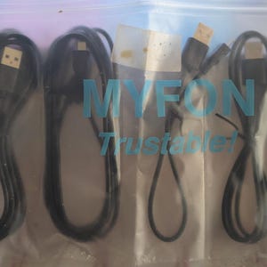 May include: A clear plastic bag containing four black USB charging cables. The bag has the text "MYFON Trustable!" printed in blue. The cables are of varying lengths and have USB connectors.