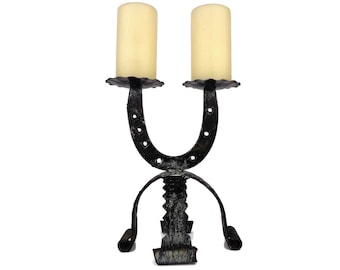 May include: Black metal candle holder shaped like a horseshoe with two candle holders on top. The candle holder is decorated with a distressed finish and has a rustic look.