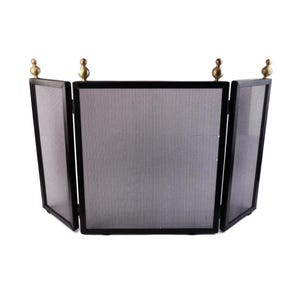 May include: A black metal fireplace screen with a mesh center panel and two side panels. The screen has three sections and is adorned with brass finials on top. The screen is designed to protect the area in front of a fireplace.