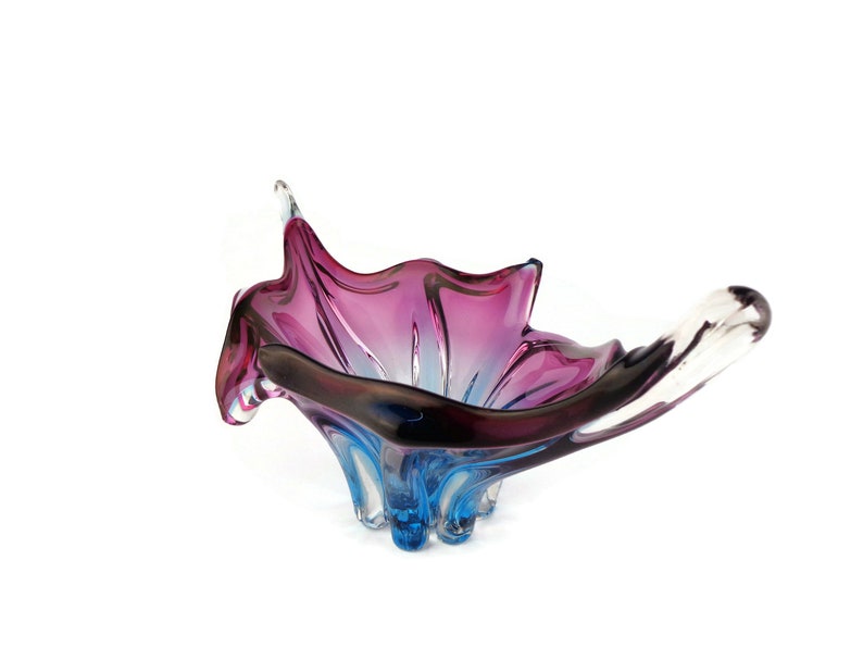Peut inclure: Un bol en verre de couleur violet et bleu avec un design ondul&eacute; et organique. Le bol est en verre transparent avec une finition iris&eacute;e violette et bleue.