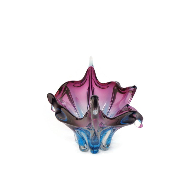 Peut inclure: Un bol en verre violet et bleu avec un design abstrait unique. Le bol est en verre souffl&eacute; &agrave; la main et a une forme ondul&eacute;e et organique.