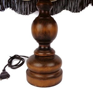 May include: A wooden table lamp base with a dark brown finish. The base has a round, bulbous shape with a smaller, round top. The lamp base has a cord with a two-prong plug.